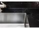 Modern stainless steel kitchen sink with dark countertop at 8807 Oak Cir, Tampa, FL 33615