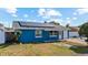 Charming single-story home showcasing a blue painted exterior, solar panels, and a well-manicured lawn at 8903 Bay Bridge Ct, Tampa, FL 33634