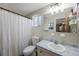 Cozy bathroom with a shower, toilet, and vanity with a sink and updated mirror at 10201 127Th Pl, Largo, FL 33773