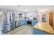 Modern kitchen with stainless steel appliances, blue and white cabinetry, and butcher block countertops at 10201 127Th Pl, Largo, FL 33773