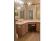 Bathroom with corner vanity, lighted mirror, and tiled floor at 11425 Billingham Blvd, Spring Hill, FL 34609