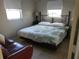 Bright bedroom with a comfortable queen-sized bed and decorative iron headboard by two windows at 12400 Park Blvd # 417, Seminole, FL 33772