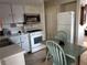 Efficient kitchen featuring white appliances, white cabinets, and a compact dining area at 12400 Park Blvd # 417, Seminole, FL 33772