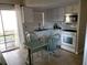 Cozy kitchen with white cabinets, appliances, a breakfast nook, and sliding glass doors to the outside at 12400 Park Blvd # 417, Seminole, FL 33772