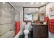 Well-lit bathroom with combination tub and shower, vanity with mirror and storage, and red accent towels at 1540 Gulf Blvd # 1705, Clearwater, FL 33767