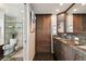 Bathroom with granite countertops, dual sinks, dark wood cabinets, and custom fixtures at 1540 Gulf Blvd # 1705, Clearwater, FL 33767