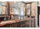 Bathroom with granite countertops, dual sinks, dark wood cabinets, and custom fixtures at 1540 Gulf Blvd # 1705, Clearwater, FL 33767