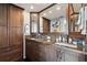Bathroom with granite countertops, dual sinks, dark wood cabinets, and custom fixtures at 1540 Gulf Blvd # 1705, Clearwater, FL 33767
