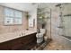 Bathroom featuring a glass shower, soaking tub, updated fixtures, and custom storage at 1540 Gulf Blvd # 1705, Clearwater, FL 33767