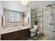 Bathroom featuring a glass shower, soaking tub, updated fixtures, and custom storage at 1540 Gulf Blvd # 1705, Clearwater, FL 33767