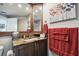 Bathroom vanity with sink, decorative flowers painting and red accent towels at 1540 Gulf Blvd # 1705, Clearwater, FL 33767