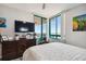 This bedroom features a waterfront balcony, ceiling fan, and a wall-mounted television above an antique dresser at 1540 Gulf Blvd # 1705, Clearwater, FL 33767