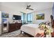This bedroom features a waterfront balcony, ceiling fan, and a wall-mounted television above an antique dresser at 1540 Gulf Blvd # 1705, Clearwater, FL 33767
