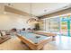 A well-lit game room showcases two billiard tables, comfortable seating, and direct access to an outdoor area at 1540 Gulf Blvd # 1705, Clearwater, FL 33767