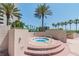 Outdoor hot tub with seating and lush tropical landscaping near a residential building and beach at 1540 Gulf Blvd # 1705, Clearwater, FL 33767