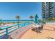 Outdoor patio with seating overlooking the pool, beach, and ocean at 1540 Gulf Blvd # 1705, Clearwater, FL 33767