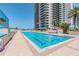 Large outdoor swimming pool and sundeck in front of high-rise residential building with palm trees at 1540 Gulf Blvd # 1705, Clearwater, FL 33767