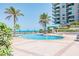 Outdoor swimming pool with palm trees and seating overlooking the white sand beach and blue ocean at 1540 Gulf Blvd # 1705, Clearwater, FL 33767