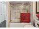 Shower and tub combination features sliding glass doors, tile walls, and shower caddy at 1540 Gulf Blvd # 1705, Clearwater, FL 33767