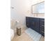 Modern bathroom with navy vanity, white countertop, and gold accents at 1613 Druid E Rd, Clearwater, FL 33756