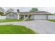 Gray house with white accents, a two-car garage, and well-manicured lawn at 1613 Druid E Rd, Clearwater, FL 33756