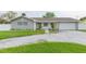 Gray house with white accents, a two-car garage, and well-manicured lawn at 1613 Druid E Rd, Clearwater, FL 33756