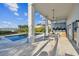 A covered back patio shows a dining area, lounging area and pool at 1640 Sea Breeze Dr, Tarpon Springs, FL 34689