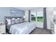 Spacious bedroom with gray upholstered bed, blue walls and window at 2073 Hallier Cv, Wesley Chapel, FL 33543