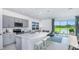 Modern kitchen with gray cabinets, island seating, and backyard access at 2073 Hallier Cv, Wesley Chapel, FL 33543