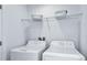 Bright laundry room, featuring washer and dryer and overhead shelving at 2073 Hallier Cv, Wesley Chapel, FL 33543