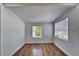Simple bedroom with hardwood floors and two windows at 3005 E Shadowlawn Ave, Tampa, FL 33610