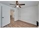 Bedroom with wood floors, ceiling fan, and laundry access at 3005 E Shadowlawn Ave, Tampa, FL 33610