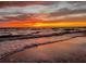 Striking sunset over the ocean, with waves gently washing onto the sandy beach at 308 2Nd St N # 202, Bradenton Beach, FL 34217