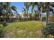 Large backyard with grassy area and tropical plants at 311 15Th Ave, Indian Rocks Beach, FL 33785
