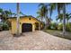 Yellow house with dark garage door and brick driveway at 311 15Th Ave, Indian Rocks Beach, FL 33785