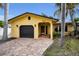 House exterior featuring a yellow facade and a dark garage door at 311 15Th Ave, Indian Rocks Beach, FL 33785