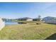 Backyard with a peaceful pond, lush green grass, and a view of neighboring homes at 3888 Almond Brook Blvd, Land O Lakes, FL 34638