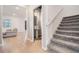Inviting hallway featuring hardwood floors, a powder room, and carpeted stairs at 3888 Almond Brook Blvd, Land O Lakes, FL 34638