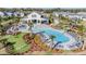Aerial view of a community pool with an outdoor amenity center, lounge seating and landscaping at 3888 Almond Brook Blvd, Land O Lakes, FL 34638