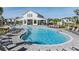 View of a modern community pool featuring ample lounge seating and a recreational amenity center, designed for leisure at 3888 Almond Brook Blvd, Land O Lakes, FL 34638