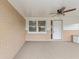 Covered front porch with brick walls, ceiling fan, and carpet flooring at 5152 Victoria Ln, Holiday, FL 34690