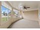 Bright sunroom with multiple windows, carpet flooring and a ceiling fan at 5152 Victoria Ln, Holiday, FL 34690