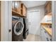 Convenient laundry room with modern washer and dryer, custom cabinetry, and sink at 5501 E Longboat Blvd, Tampa, FL 33615