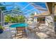 Backyard pool with a full enclosure, featuring lounge chairs and lush landscaping at 5501 E Longboat Blvd, Tampa, FL 33615