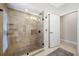 Shower with travertine tile, glass door, and built-in shelves at 5501 E Longboat Blvd, Tampa, FL 33615