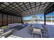 Covered patio featuring outdoor seating around a dining table and lounge space with view of the community pool at 6218 Timberdale Ave, Wesley Chapel, FL 33545