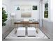 Bright home office with wood desk and two ottomans at 6238 Timberdale Ave, Wesley Chapel, FL 33545