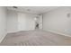 Neutral toned bedroom with carpeted floor, white doors and a view to the stairwell at 7055 Summer Holly Pl, Riverview, FL 33578