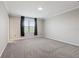 Spacious bedroom with plush carpeting, a large window, and neutral gray walls at 7055 Summer Holly Pl, Riverview, FL 33578