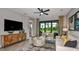 A bright living room with a neutral color palette, wood-look flooring, stylish furniture, and access to the pool at 750 Steel Dr, Apollo Beach, FL 33572